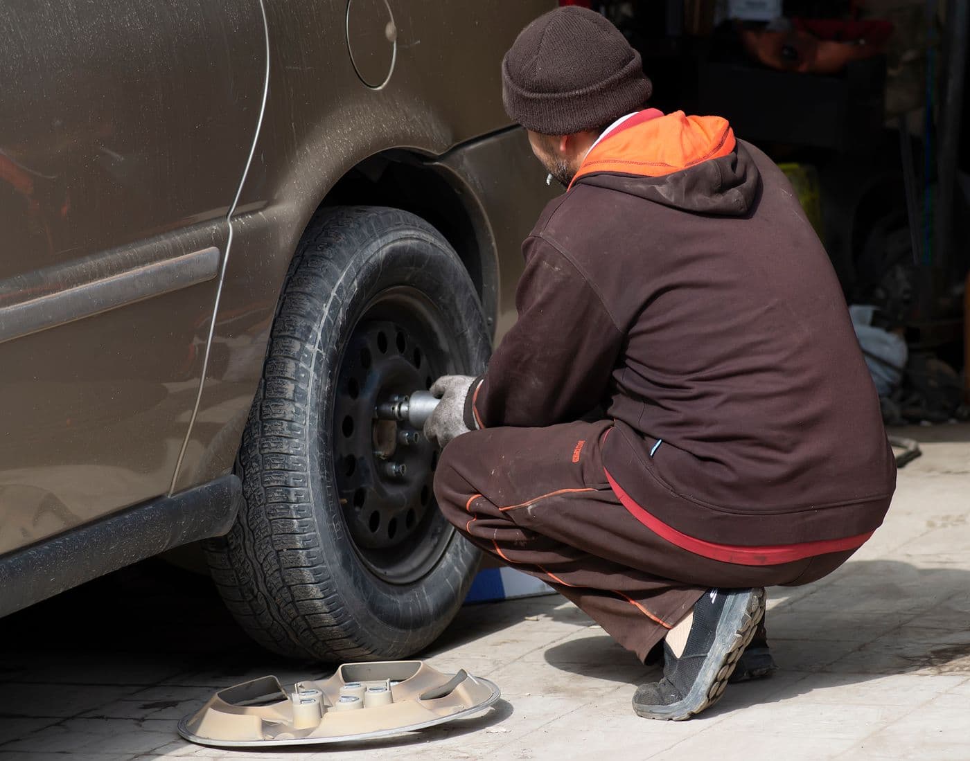 Tire installer servicing a vehicle wheel